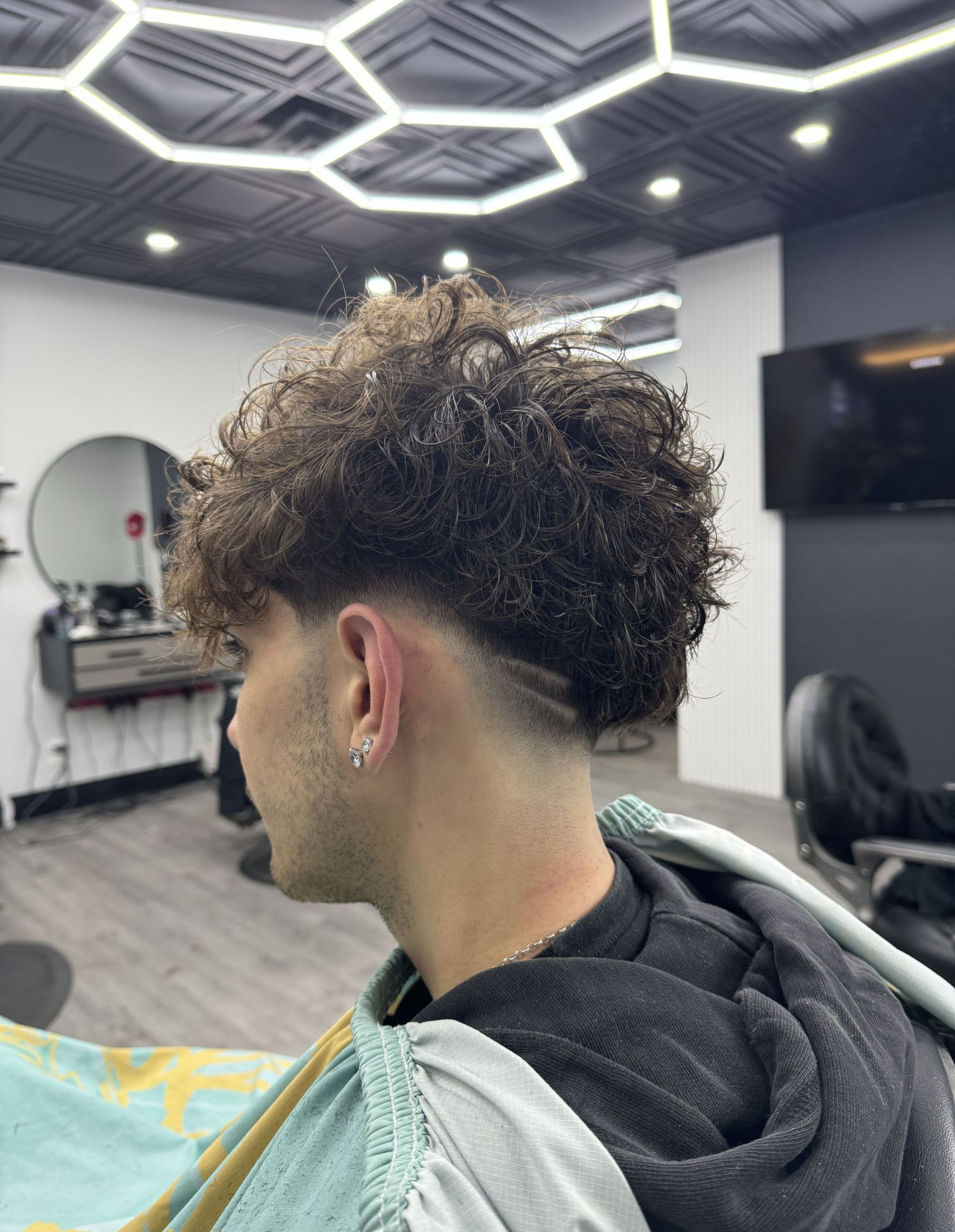 Textured curly fade with design at East Blendz